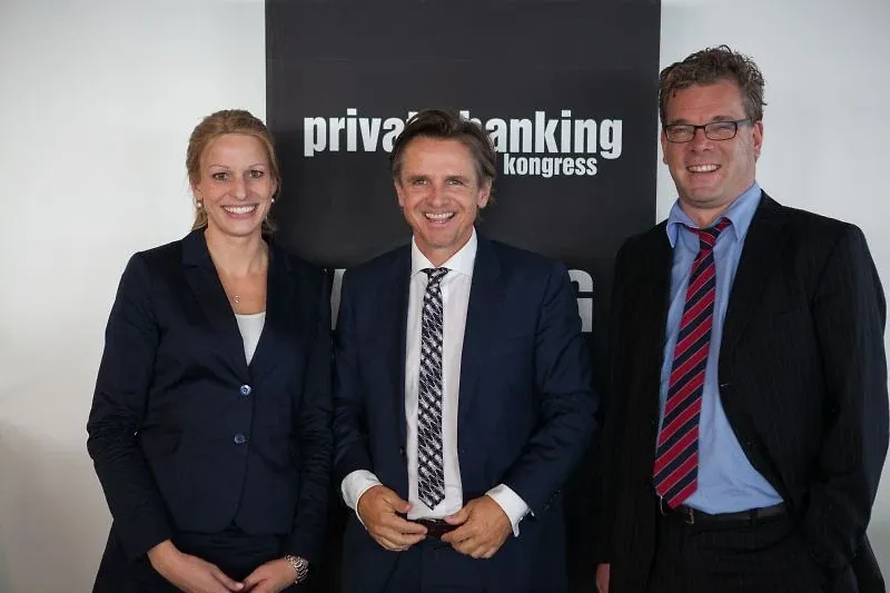 Drei Personen in dunklen Anzügen stehen nebeneinander vor einer schwarzen Wand mit dem Schriftzug „private banking kongress“