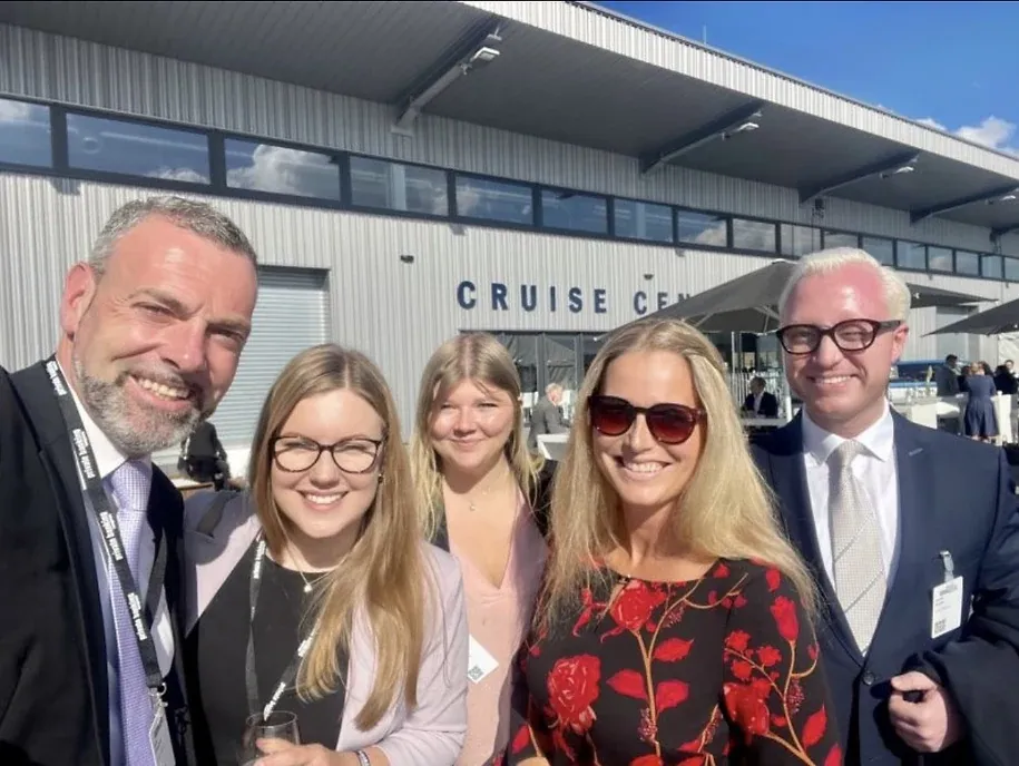 Selfie von fünf Personen in Businesskleidung vor einem Gebäude mit dem Schriftzug „Cruise Center“